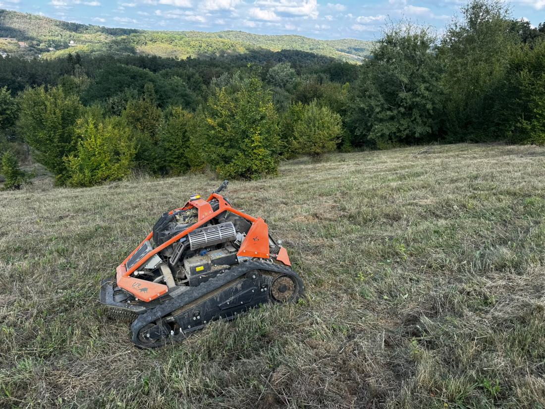 Mașina GreenCut pe o pantă cu vegetație